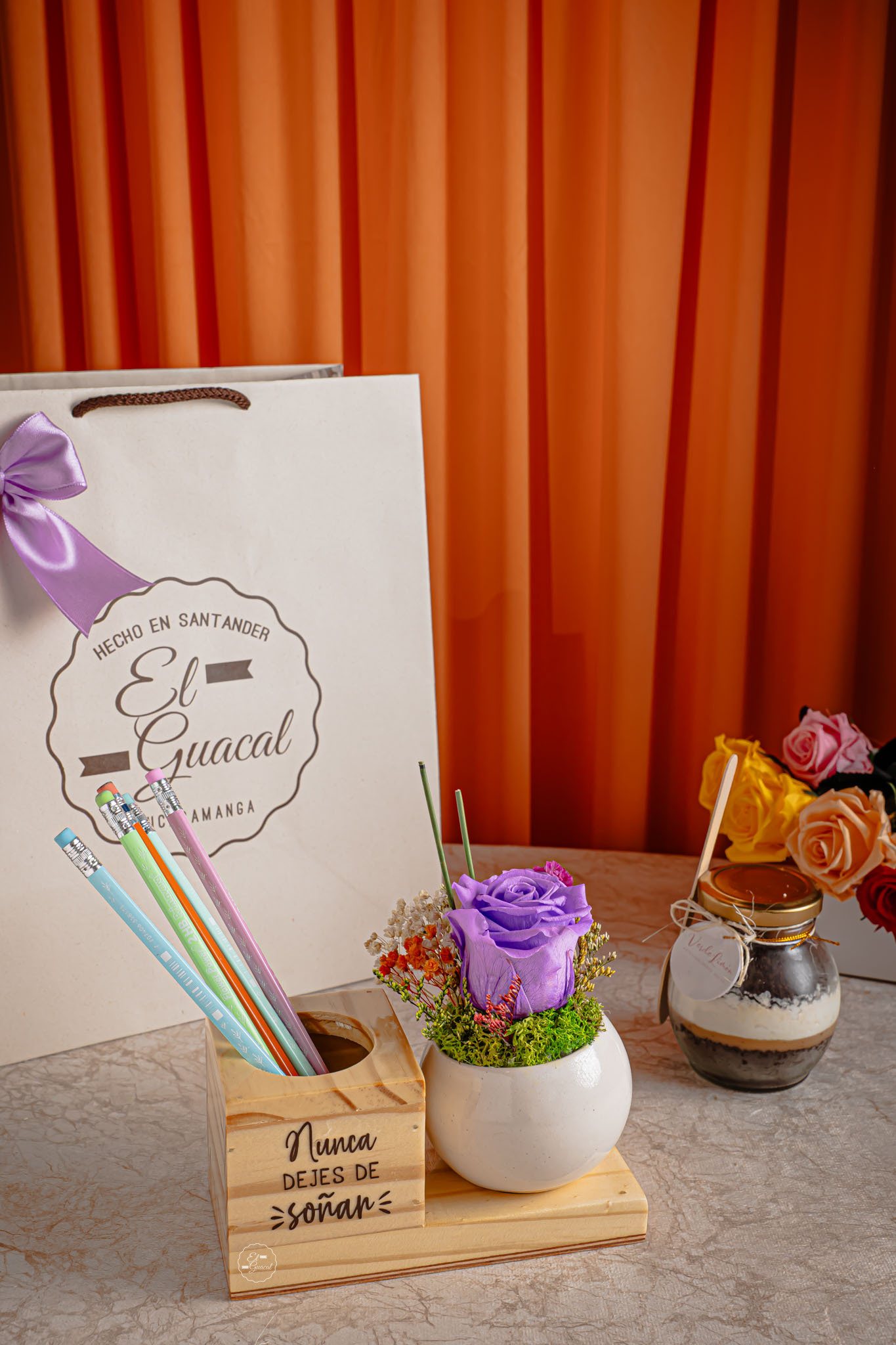-Bolsa de regalo -Portalápices con rosa preservada en maceta de cerámica -Postre artesanal -Tarjeta con mensaje y de/para